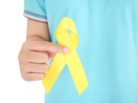 Woman hand holding yellow ribbon, sarcoma awareness, bone cancer, childhood cancer awareness, September yellow, World Suicide Prevention Day.