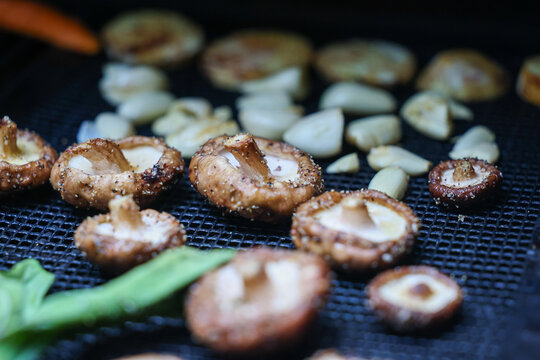 Farm fresh garden vegetables cooking on a pellet grill smoker for a vegetarian dinner. The healthy food is colorful and packed with vitamins and garden nutrients. Delicious!