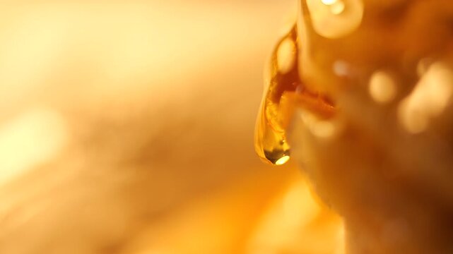 50p side view macro shot of golden honey slowly dripping