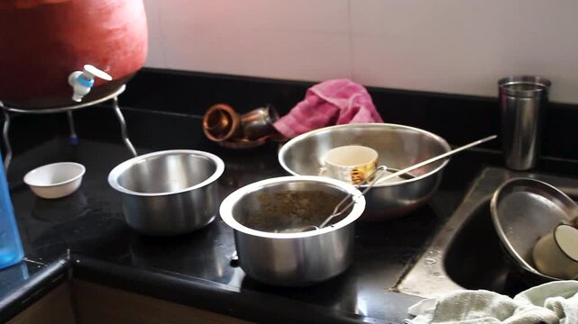 Close view of unwashed dishes, cookware and utensils stacked in a kitchen sink after cooking. Ideal for cleaning, household chores, domestic lifestyle, hygiene and busy family home concepts.