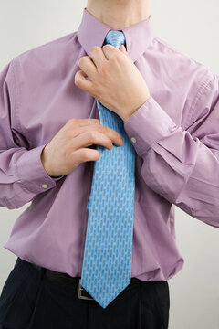 Mid section view of a businessman adjusting his tie
