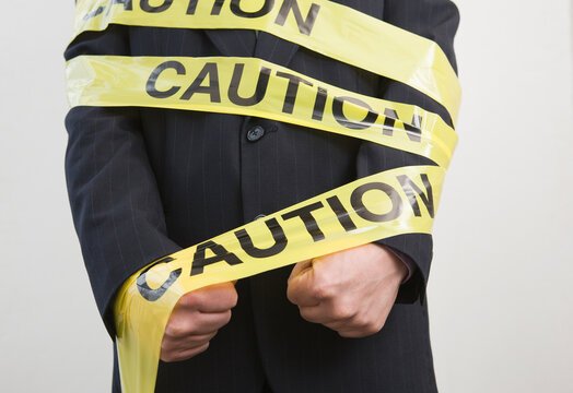 Mid section view of a businessman wrapped in a Caution tape