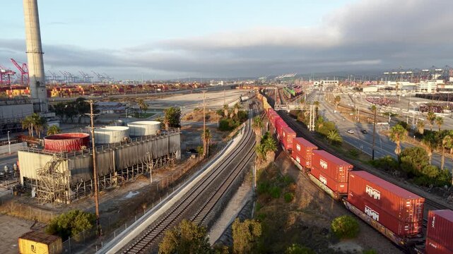 An aerial drone view of a massive amount of shipping containers pouring into the Port of Los Angeles by way of Freight Train.