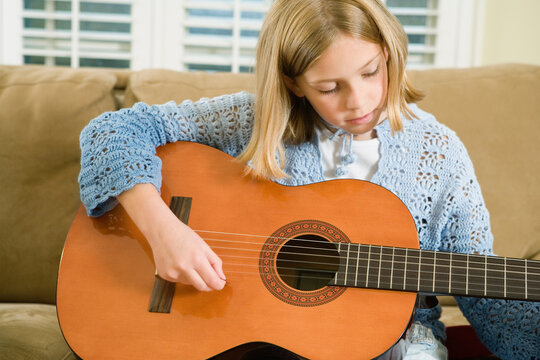 View of a cute girl playing a guitar