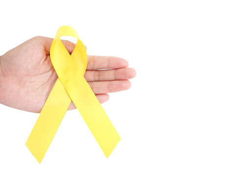 Woman hand holding yellow ribbon, sarcoma awareness, bone cancer, childhood cancer awareness, September yellow, World Suicide Prevention Day.