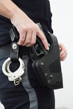 Police womn removing gun from the holster