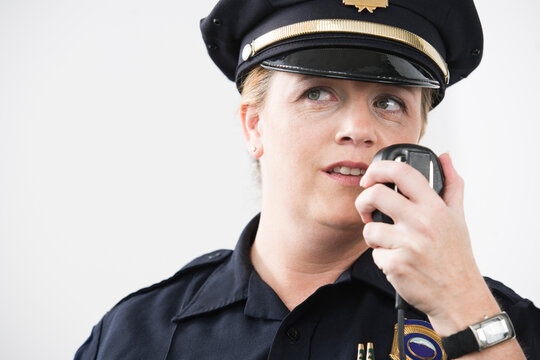 Woman police officer talking on hand mike