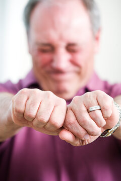 View of a mature man holding hands to be tied