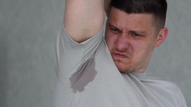 Sweaty armpits on a man's gray T-shirt.
Sweat stains on clothing in hot weather