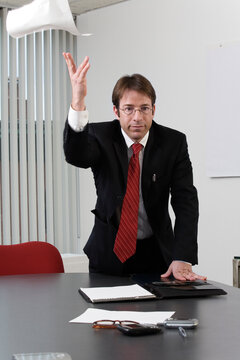 Portrait of a business man throwing paper