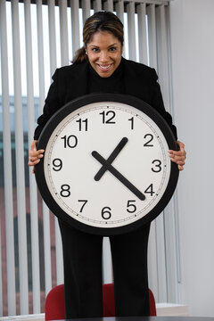 Portrait of a business woman holding wall clock