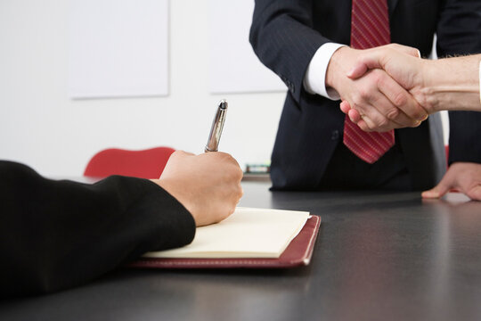 Midsection of business men shaking hands at an office