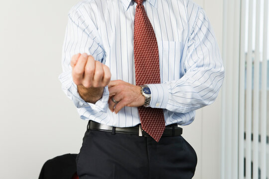 View of a businessman rolling up sleeves