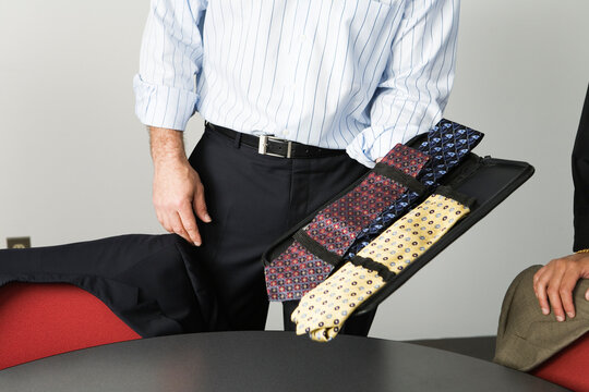 View of a businessman holding neckties