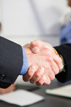 View of businessmen shaking hands in an office