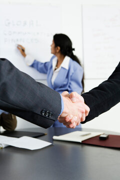 View of businessmen shaking hands in an office