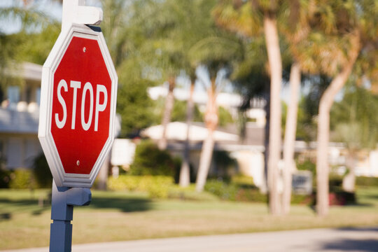 Close-up of a stop sign with a tourist resort in the background