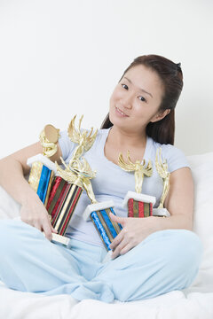 Portrait of a young woman holding trophies