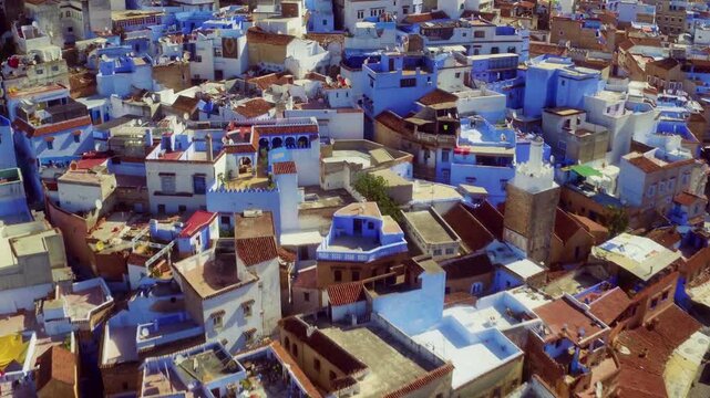 Drone advances over Chefchaouen's blue rooftops revealing inner courtyards
