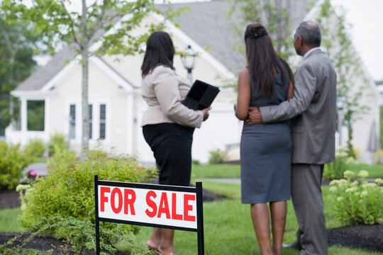 Middle-aged couple with a real estate agent looking at a house
