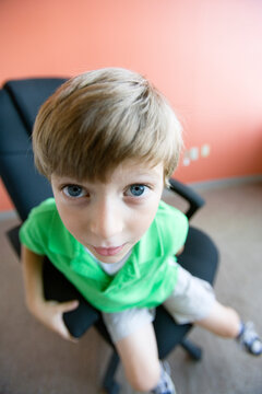 Close up of a boy sitting on a chair
