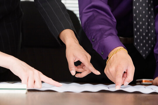 View of people pointing fingers on paper