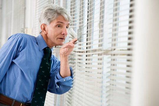 A business man looking out from his office window