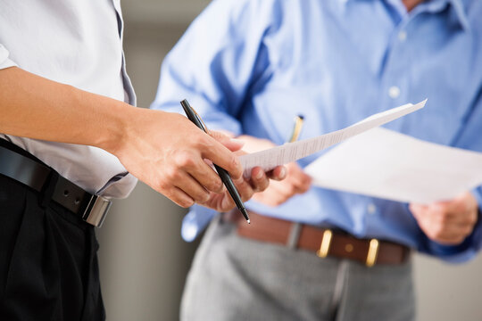 Close up of business men holding documents in an office