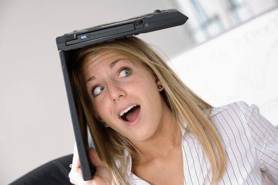 A business woman with a laptop over her head