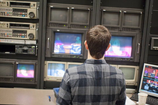 Video editor at work in a TV editing control room at a Cable TV Studio