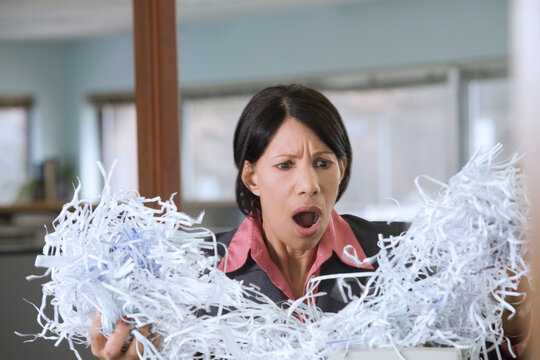 Businesswoman holding shredded papers