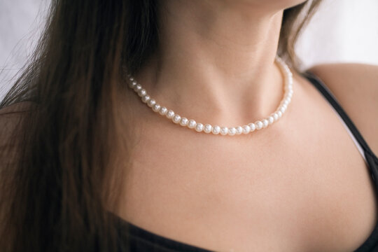 Midsection of a woman wearing pearl necklace