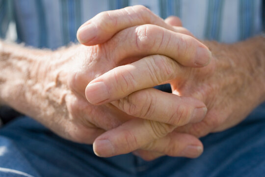 Mid section view of a senior man with his hands clasped