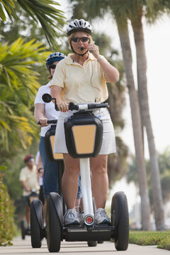 Two mid adult women riding segways in a garden