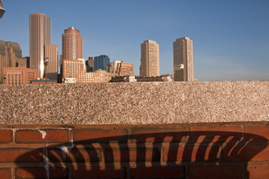 Shadow of trash container with Rowes Wharf in background