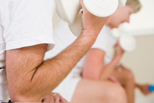 Mid section view of a senior man exercising with hand weights