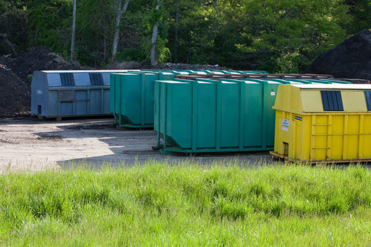 Four recycling containers at a public recycling center, two for trash and two for recycling