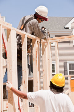 Carpenters sawing a wall stud