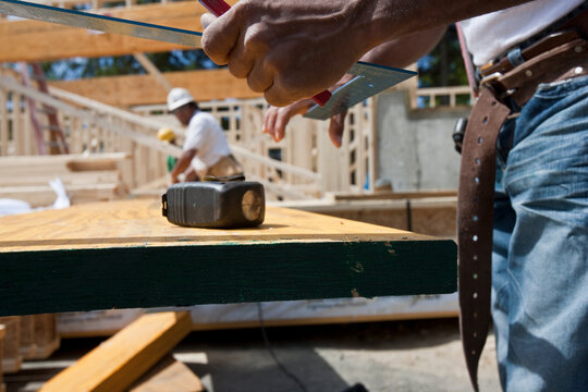 Carpenter holding steel square at a construction site