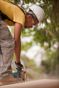 Carpenter sawing a particle board