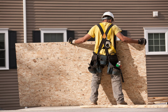 Carpenter positioning a particle board