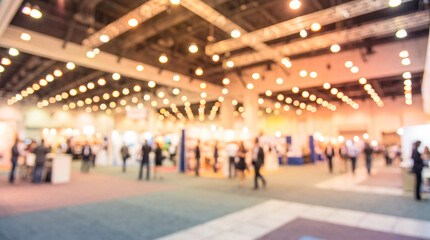 Fototapeta premium Blurred view of a busy convention center with many people and bright overhead lights
