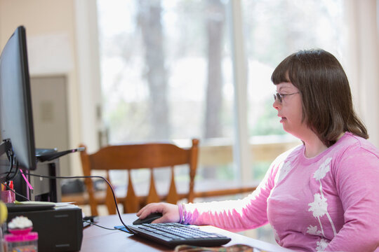 Girl with Down Syndrome using her computer