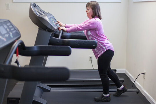 Girl with Down Syndrome working out on an exercise machine