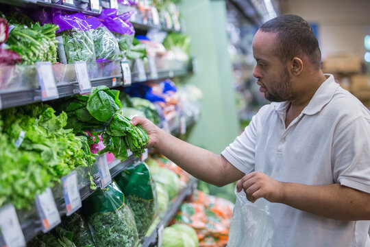 Man with Down Syndrome picking out food in a grocery store