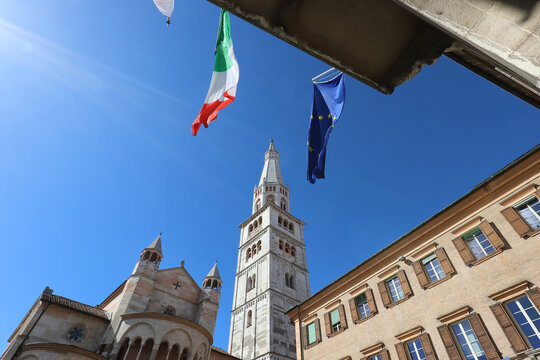 Ghirlandina (garland) tower, Modena, Emilia, Italy, UNESCO World Heritage Site, tower spire in the blue sky with flags