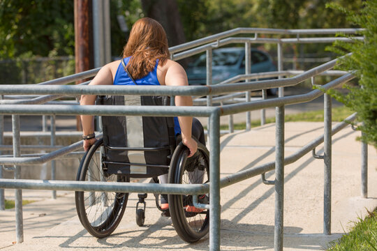 Woman with a spinal cord injury using a wheelchair ramp