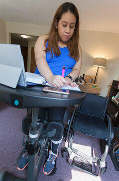Woman with spinal cord injury working on her desk with a brace