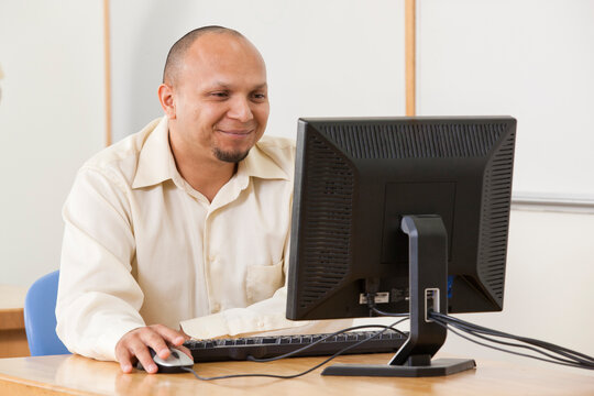 Engineering student studying computer display in a classroom