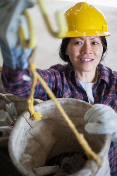 Female power engineer preparing canvas bucket in service garage